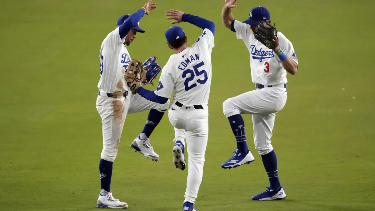 2024年10月26日,洛杉磯道奇以4比2拿下世界大賽第二勝後,Chris Taylor、Tommy Edman和Mookie Betts在場中慶祝。(美聯社)