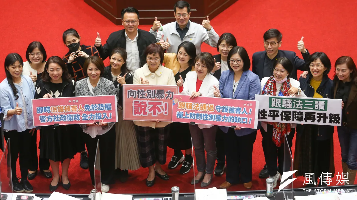 立法院19日三讀通過跟騷法,民進黨立委於議場內舉牌合影。(顏麟宇攝)