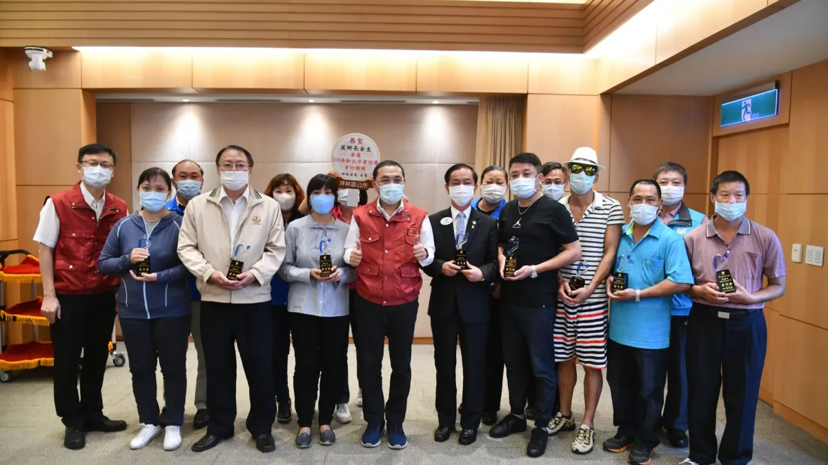 新北市長侯友宜頒發獎座給109年新北市孝行獎孝行楷模得主,與他們合影留念。(圖/新北市教育局提供)