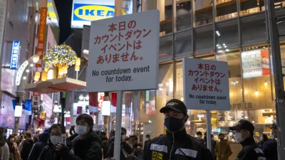 為了避免跨年倒數的人潮聚集,日本警方2020年12月31日在東京澀谷舉牌引導民眾離開。(美聯社)