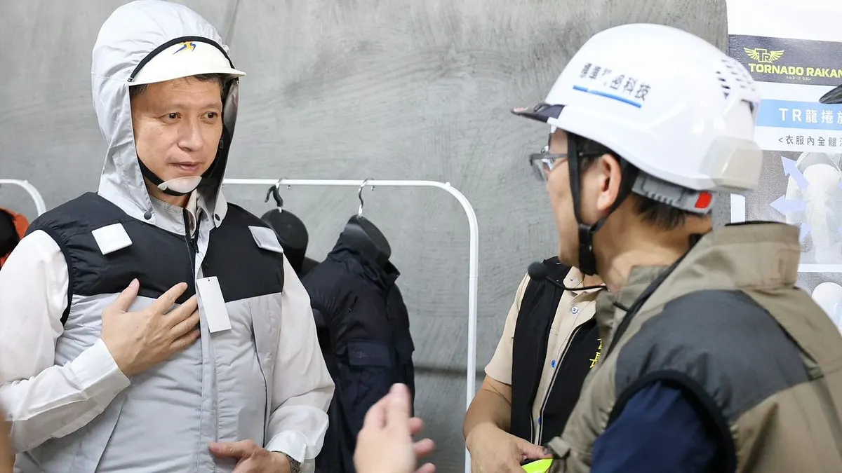 新北市勞工局長陳瑞嘉(左) 示範「風扇衣」功能,它能有效降低熱危害風險。(圖/新北勞工局提供)