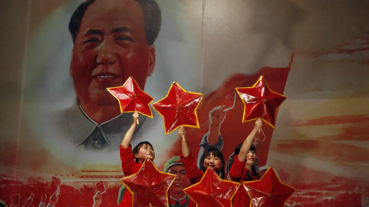 2011年5月2日,表演者在北京一間紅色餐廳登台,舞台上還有毛澤東的照片。(美聯社)