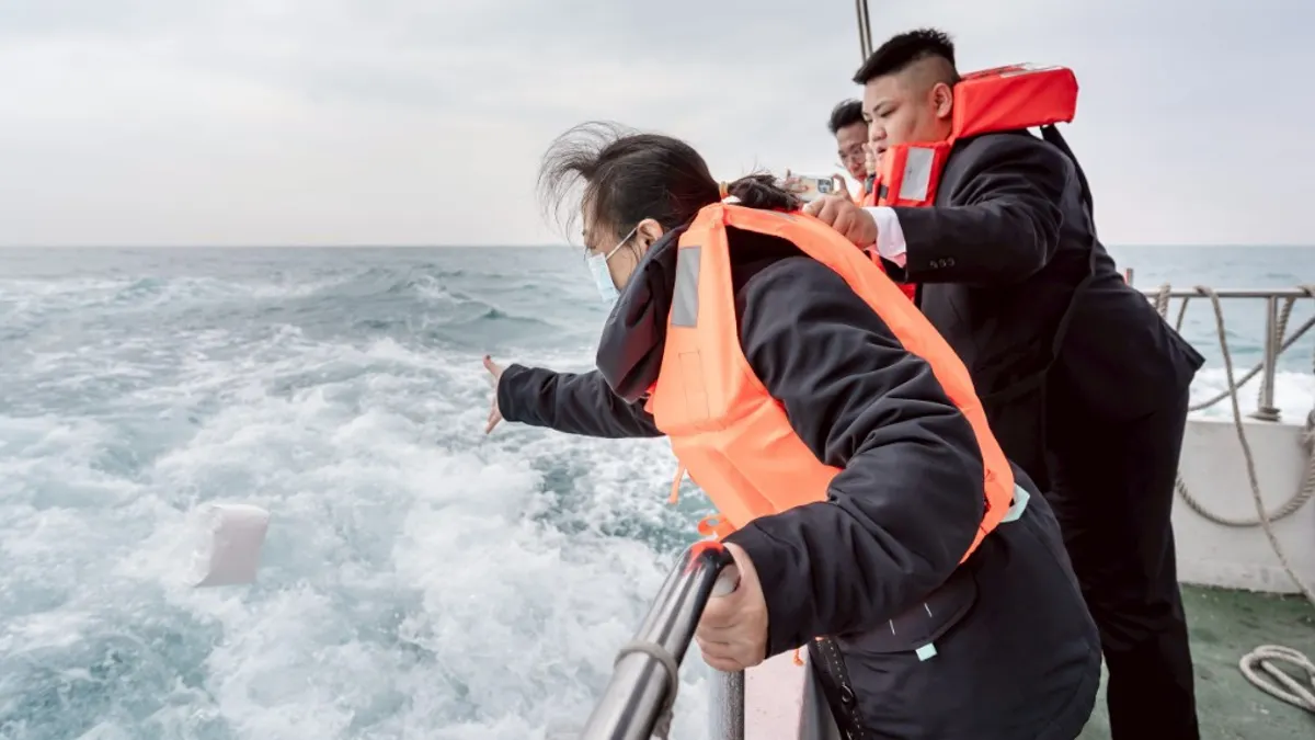 家屬向大海拋撒亡者安息骨灰。(圖/高市民政局提供) 家屬向大海拋撒亡者安息骨灰。(圖/高市民政局提供)