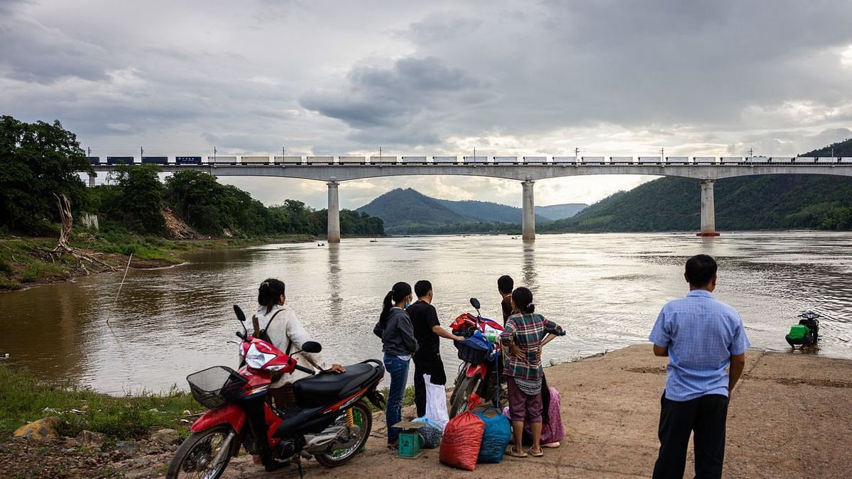 在寮國琅勃拉邦,正在賣蘑菇的當地人停下來,看火車駛過湄公河上的一座新大橋。(圖片來源:華爾街日報) 在寮國琅勃拉邦,正在賣蘑菇的當地人停下來,看火車駛過湄公河上的一座新大橋。(圖片來源:華爾街日報)