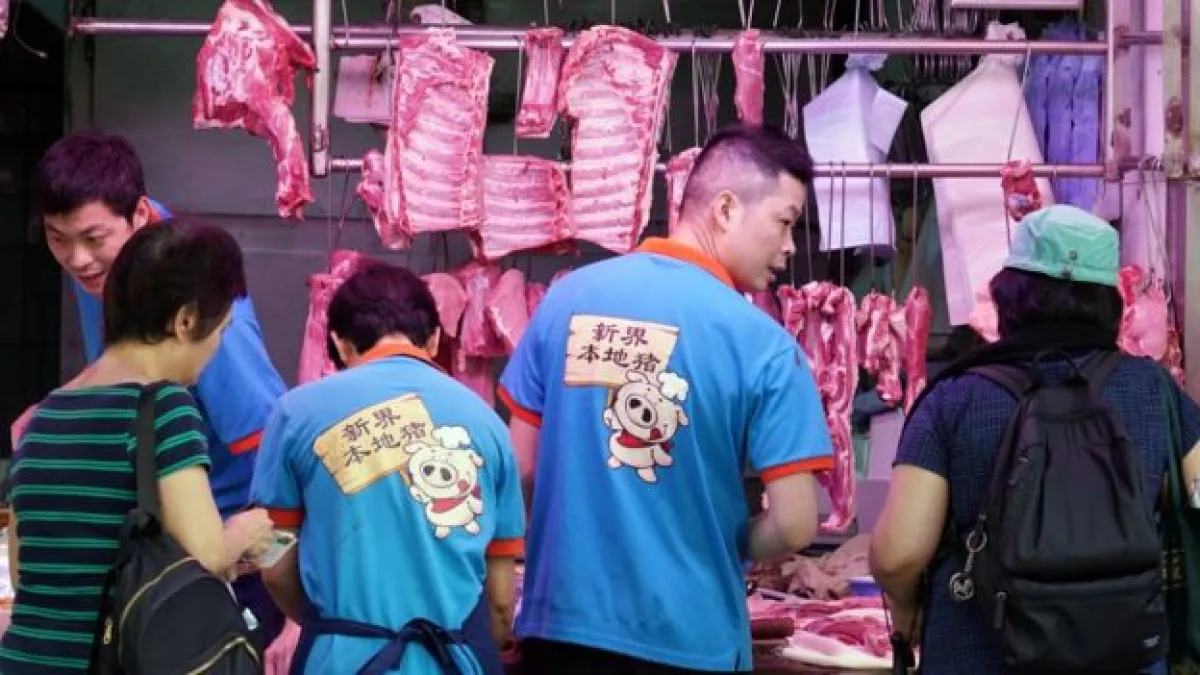 香港灣仔一家肉店店員穿上「新界本地豬」制服招攬顧客。(BBC中文網)