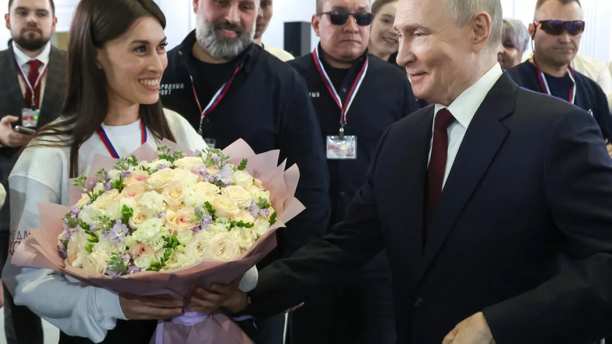 Russian President Vladimir Putin is presented with a bouquet prior to his annual press conference. (AP)