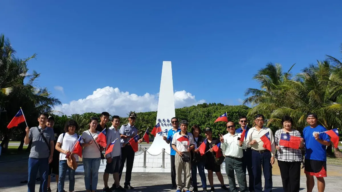 南沙指揮部指揮官張尹俊上校與登島眷屬於太平島國碑前合影。(圖/海洋委員會海巡署提供)