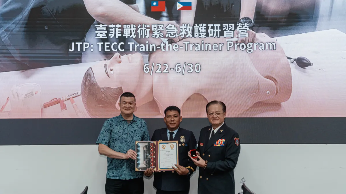 Taiwan's Deputy Minister of the Interior Ma Shih-Yuan (left) presents a graduating firefighter with his certificate of completion. (Provided by TAEF)