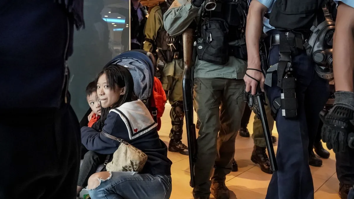 香港沙田區新城市廣場示威活動中,一名女子在警察經過時護著孩子。(ANTHONY KWAN FOR THE WALL STREET JOURNAL)