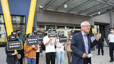 郭倍宏率助理戴上「黑名單」的黑色面具,手舉「警察勿淪為政治打手」、「人民有握手發傳單的權利」等標語,至鼓山分局抗議。(圖/郭倍宏服務處提供)