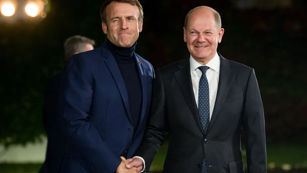 法國總統馬克宏穿著高領上衣現身,右為德國總理蕭爾茨(Olaf Scholz)。(AP)