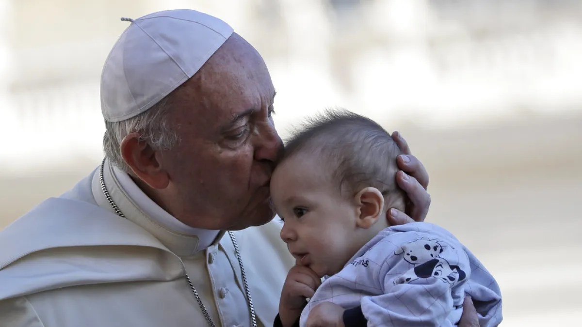 教宗方濟各9月12日在梵蒂岡聖彼得廣場(St. Peter's Square)親吻一孩童的額頭。(AP)