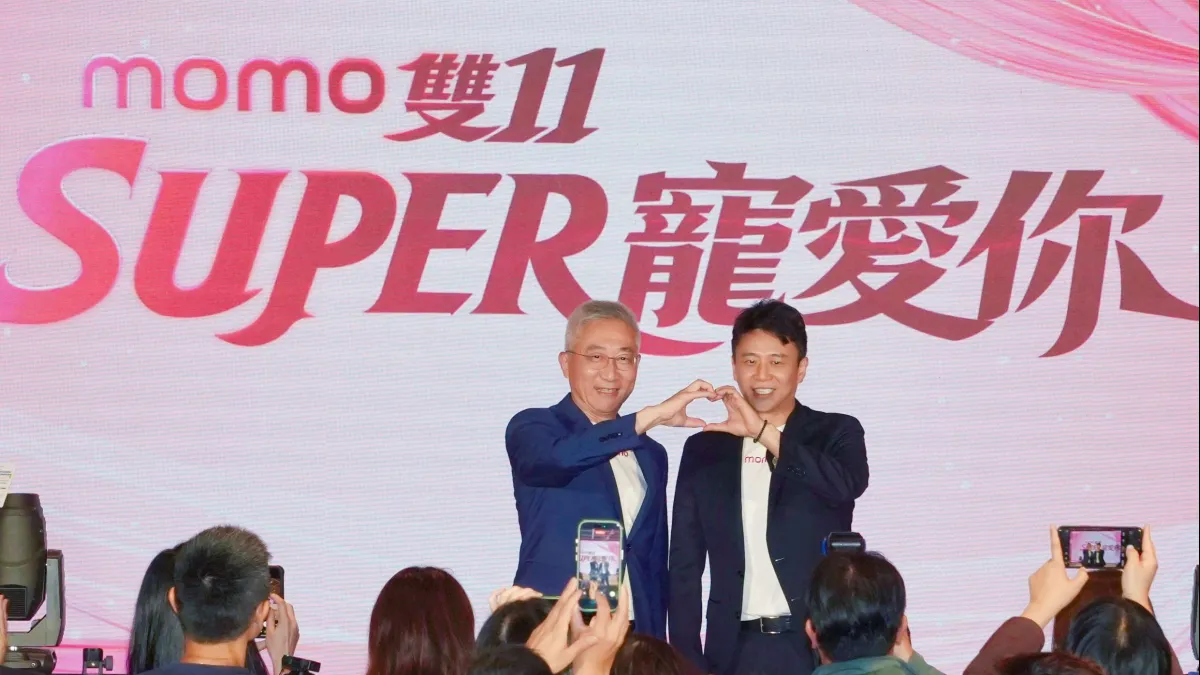 momo富邦媒總經理谷元宏(左)與資深副總經理洪偉釗(右)復刻momo雙11大使SUPER JUNIOR-83z利特、希澈合體用手比愛心。(momo提供)