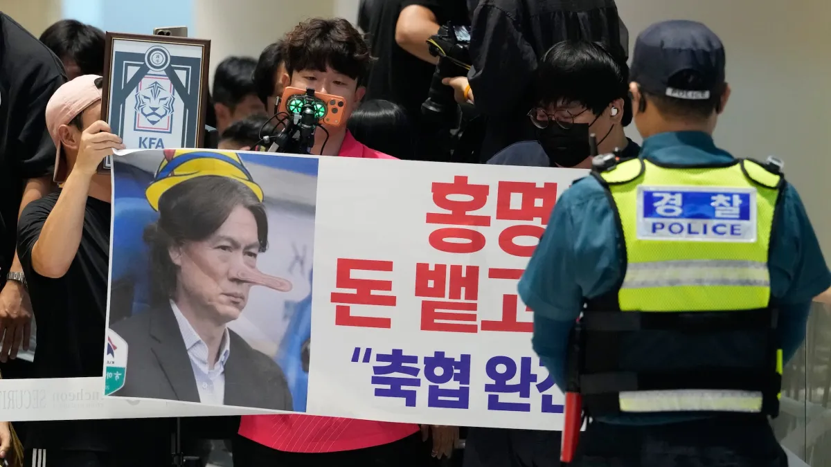 2026年6月30日,韓國仁川國際機場,韓國足球隊總教練洪明甫因球隊淘汰主動辭職,球迷在機場高舉抗議布條「洪明甫!把錢吐出來滾蛋!解散韓國足協!」(美聯社)