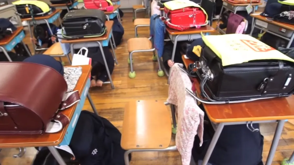 正確動作是「雙肘雙膝跪姿、頭部壓低、雙手緊握桌腳」而不是蹲姿、雙手護頭。(示意圖/翻攝自youtube) 正確動作是「雙肘雙膝跪姿、頭部壓低、雙手緊握桌腳」而不是蹲姿、雙手護頭。(示意圖/翻攝自youtube)