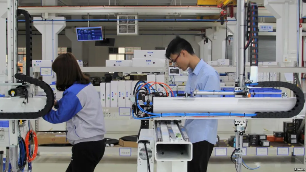 工人們在東莞一家工廠測試工業機器人(VOA)