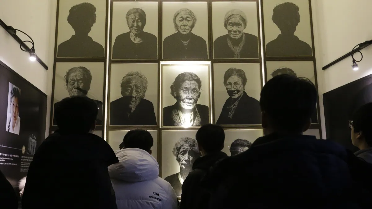 南韓的高中生在京畿道廣州市的「分享之家」觀看已過世的慰安婦阿嬤照片。(美聯社)