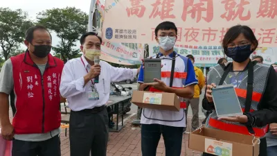 市府經發局提前一週於凱旋青年夜市演練發放第二波商圈夜市券,呂主任秘書德育現場說明行動服務人員,使用平板電腦驗證及拍照。(圖/高市府經發局)