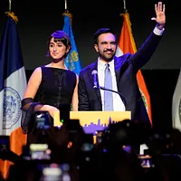 新任ニューヨーク市長に選ばれたマンマダニ氏(右)と、アーティストの妻ラマ・ドゥワジ氏(左)が勝利会見に臨む。(AP通信) 新任ニューヨーク市長に選ばれたマンマダニ氏(右)と、アーティストの妻ラマ・ドゥワジ氏(左)が勝利会見に臨む。(AP通信)