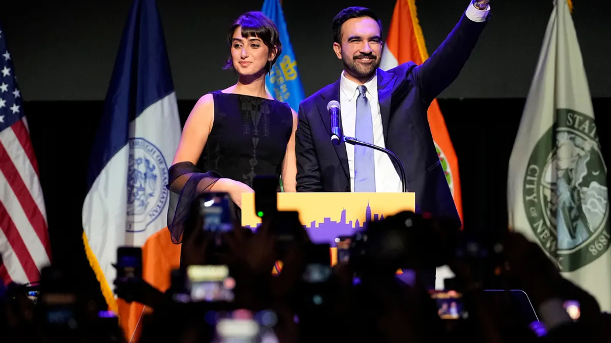 新任ニューヨーク市長に選ばれたマンマダニ氏(右)と、アーティストの妻ラマ・ドゥワジ氏(左)が勝利会見に臨む。(AP通信) 新任ニューヨーク市長に選ばれたマンマダニ氏(右)と、アーティストの妻ラマ・ドゥワジ氏(左)が勝利会見に臨む。(AP通信)