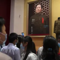 遊客在北京新開幕的中共紀念館觀看毛澤東的照片,他當時正在天安門的城樓上宣布新中國的成立。(美聯社) 遊客在北京新開幕的中共紀念館觀看毛澤東的照片,他當時正在天安門的城樓上宣布新中國的成立。(美聯社)