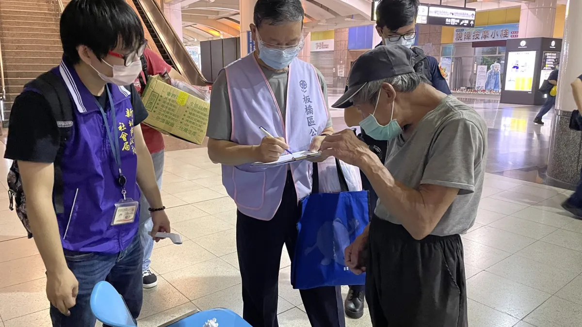 新北社會局同仁會同相關單位夜訪街友,為他們量測體溫、致贈防疫包,並勸導入住中途之家。(圖/新北市社會局提供)