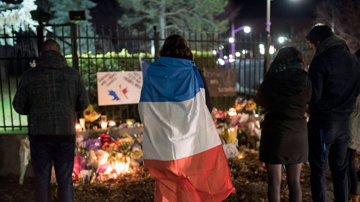 一名民眾披著法國國旗表達哀悼。(美聯社) 一名民眾披著法國國旗表達哀悼。(美聯社)