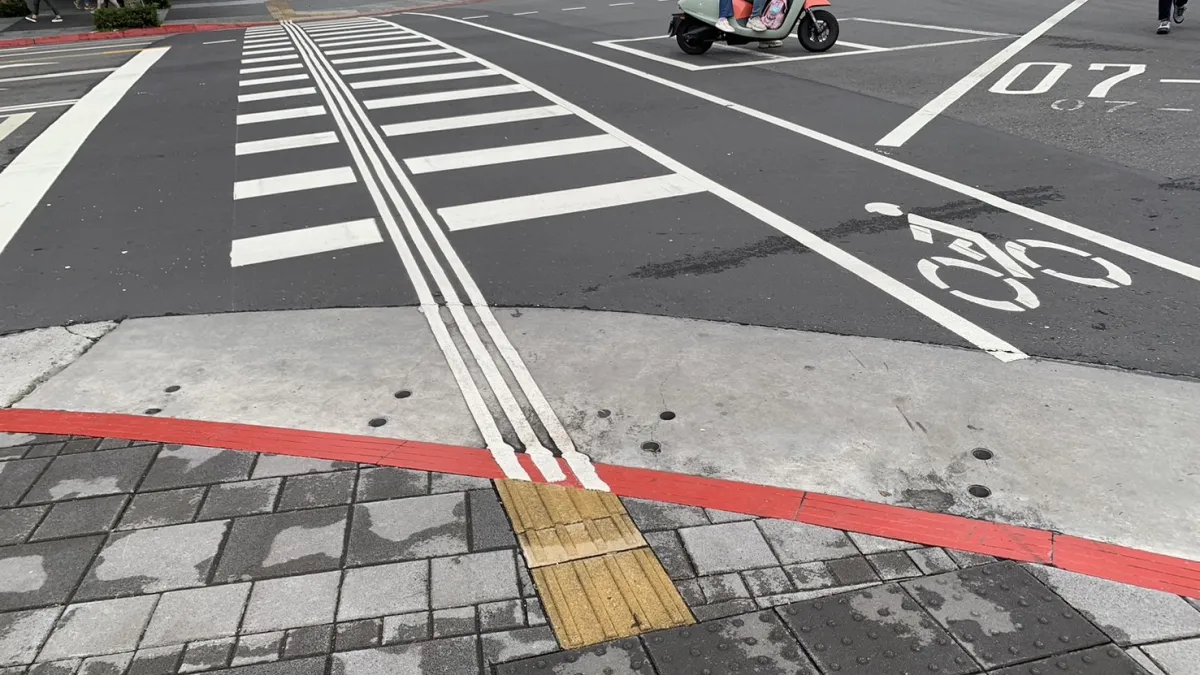 為提升視障朋友通過路口的安全,交通局在鄰近醫院及火車站、捷運站周邊計47處路口增設的視覺功能障礙引導標線。(資料照,新北市政府交通局)