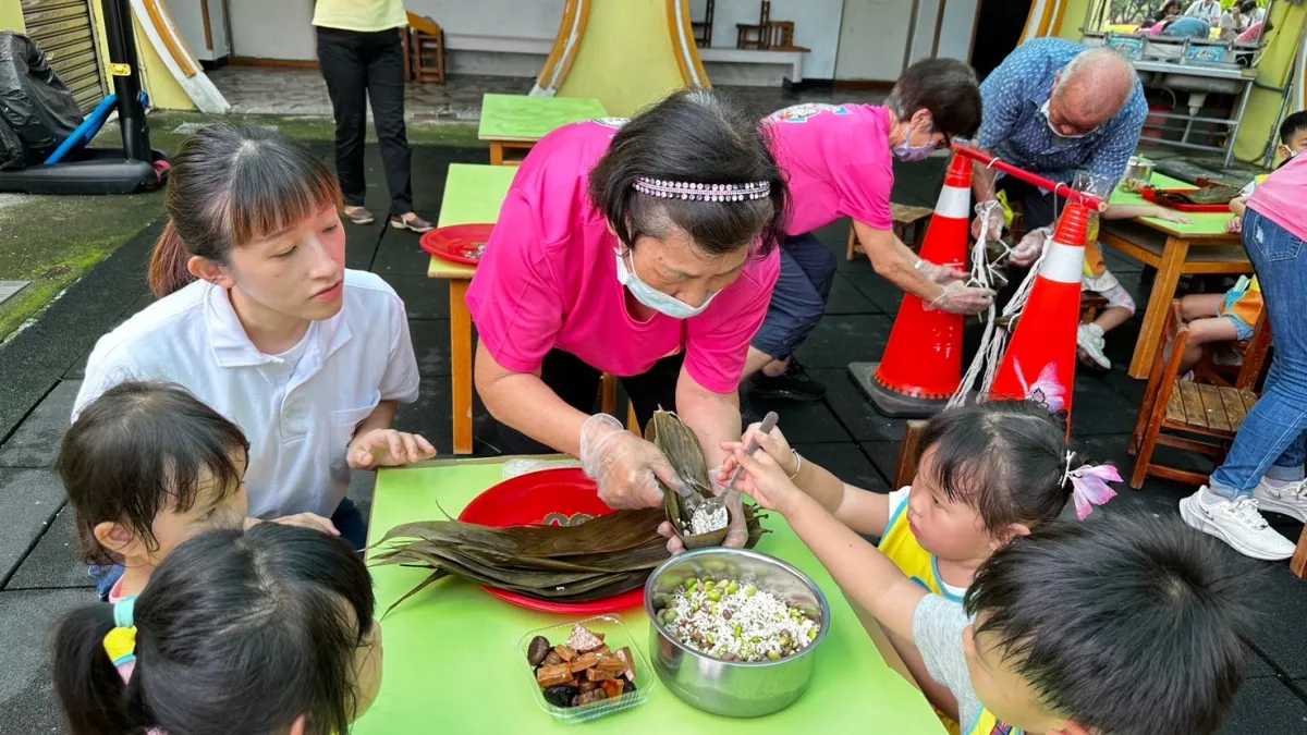 嘉義縣社區營養推廣中心推動老幼營養雙向扎根,前往六腳鄉立幼兒園與學童互動體驗包粽樂趣。(圖/嘉義縣政府衛生局提供)