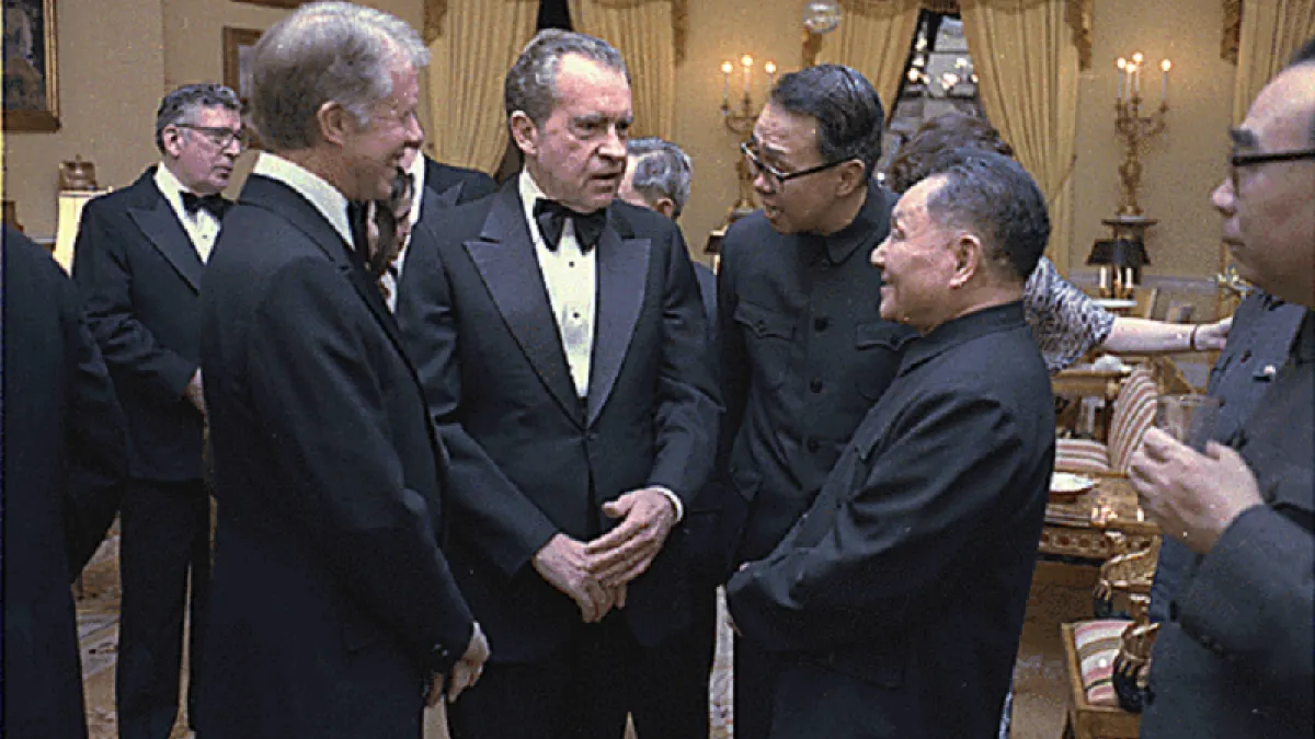 1979年,尼克森在白宮與中華人民共和國國務院副總理鄧小平交談,一旁的是總統吉米·卡特。(維基百科)
