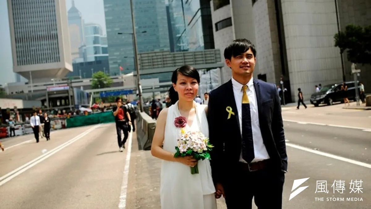 一對香港新婚夫妻在抗爭地點前合影(美聯社)