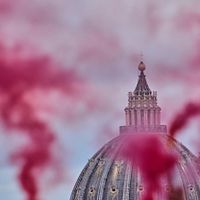 2025年5月7日、聖ペトロ大聖堂を見下ろす公園で、カトリック女性団体「婦人按立会議」のメンバーが信号弾でピンクの煙を立ち昇らせる。(AP通信) 2025年5月7日、聖ペトロ大聖堂を見下ろす公園で、カトリック女性団体「婦人按立会議」のメンバーが信号弾でピンクの煙を立ち昇らせる。(AP通信)