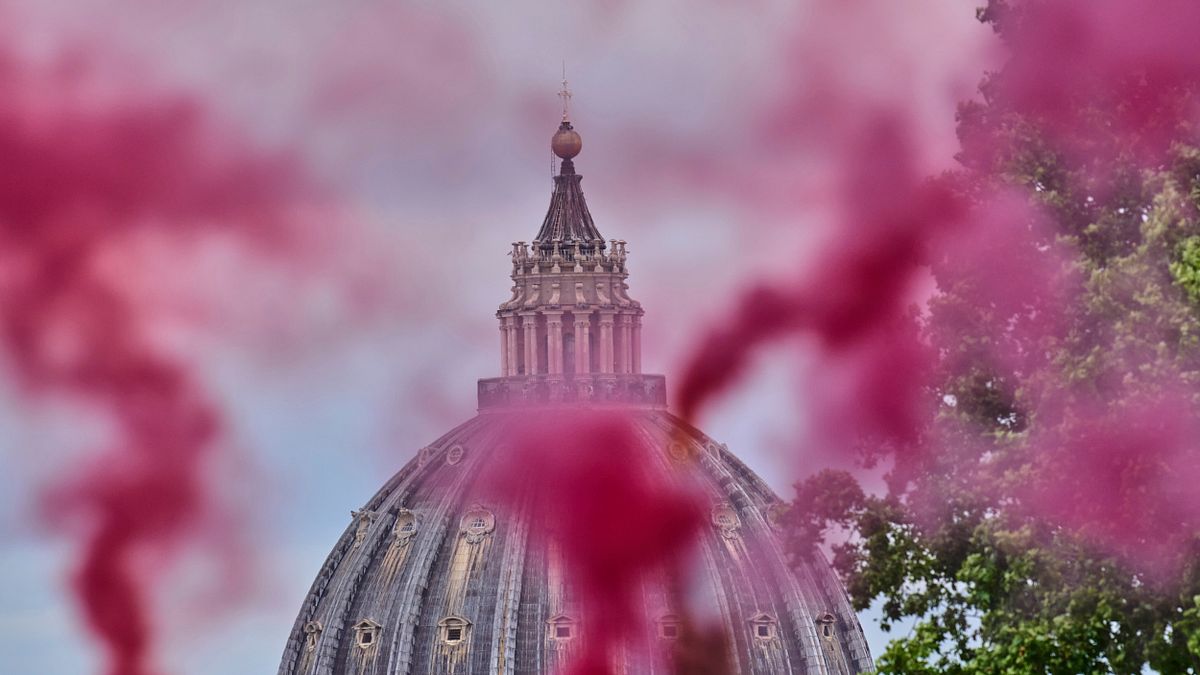 2025年5月7日、聖ペトロ大聖堂を見下ろす公園で、カトリック女性団体「婦人按立会議」のメンバーが信号弾でピンクの煙を立ち昇らせる。(AP通信) 2025年5月7日、聖ペトロ大聖堂を見下ろす公園で、カトリック女性団体「婦人按立会議」のメンバーが信号弾でピンクの煙を立ち昇らせる。(AP通信)