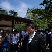 参政党代表の神谷宗幣(中央)が靖国神社を訪れた。(AP通信) 参政党代表の神谷宗幣(中央)が靖国神社を訪れた。(AP通信)