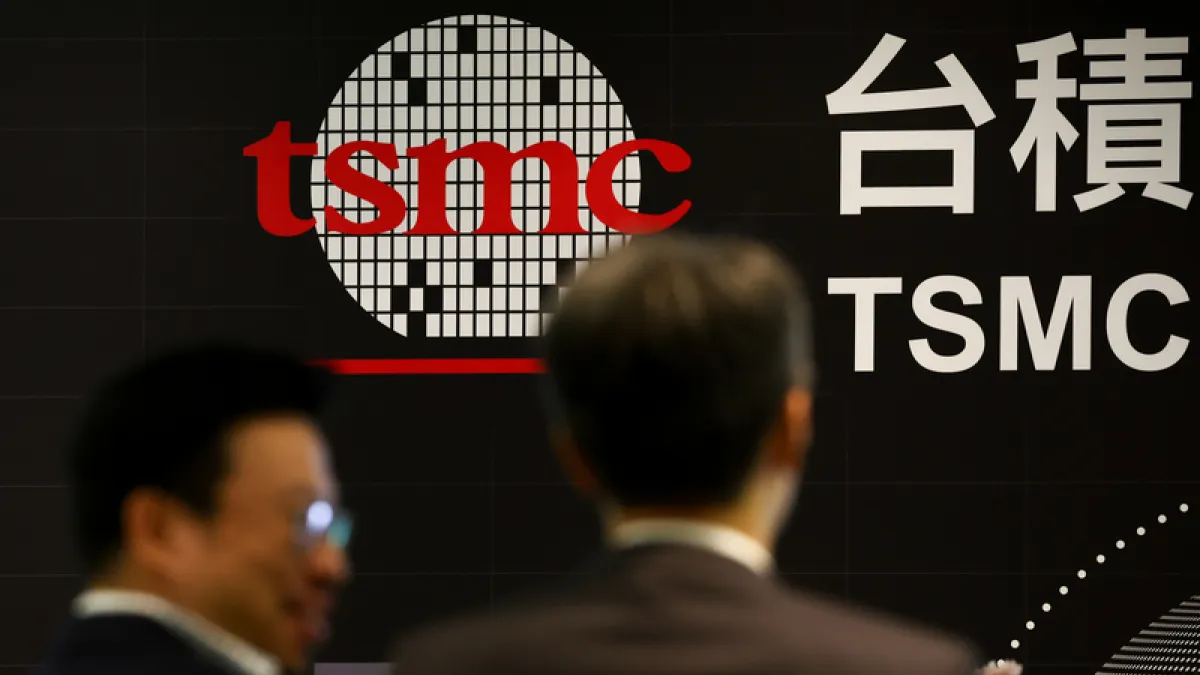 Attendees stand in front of a TSMC display at an industry event. (Photo: CNA)