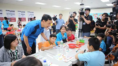 朱立倫市長觀看中華雙和基都之家、新店區喜樂心靈關懷協會、喜樂家族社會福利基金會小朋友彩繪的成品。(圖/新北市政府提供)