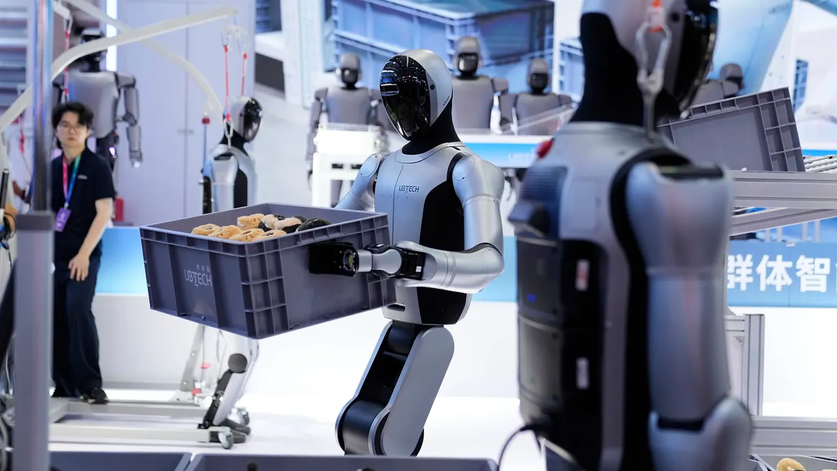 中美間的大國博弈會以AI定勝負?圖為去年中國北京世界機器人大會首日,一台人形機器人正在搬運箱子。(資料照片,美聯社)