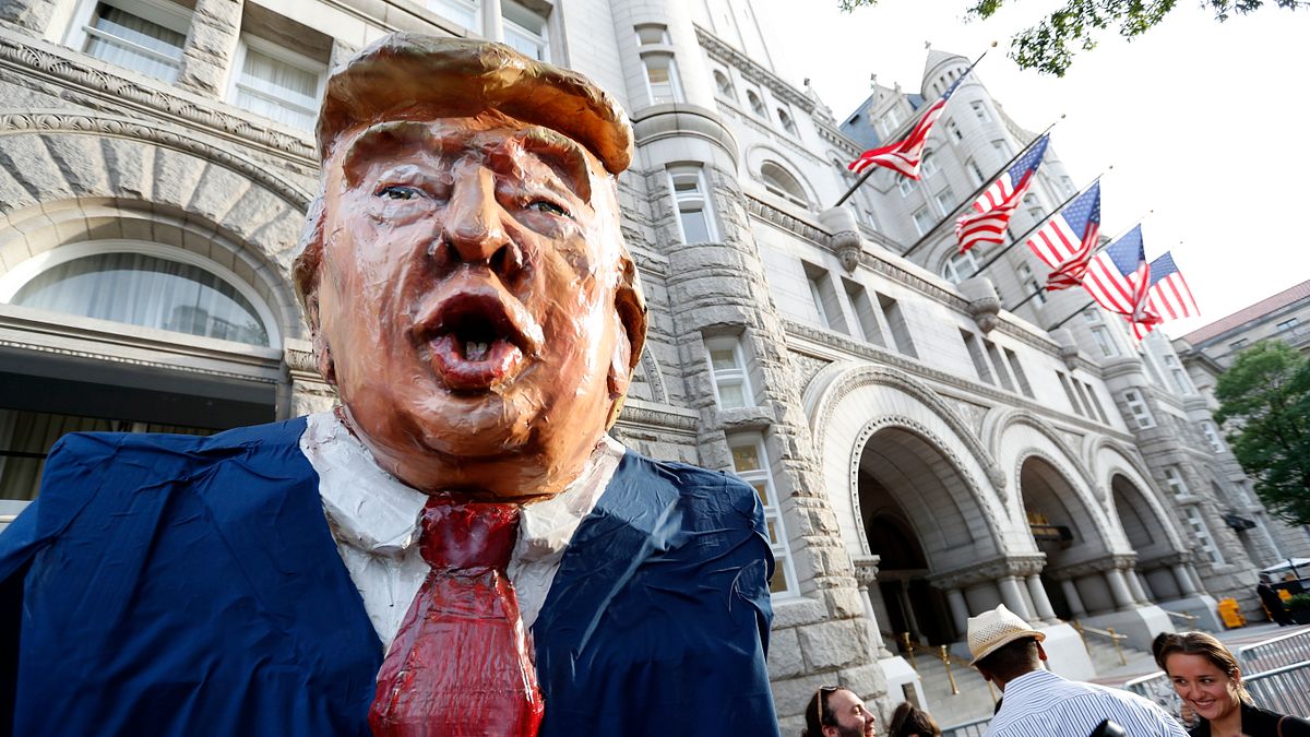 川普在華盛頓的川普國際飯店舉行募款餐會,場外聚集抗議人潮。(美聯社) 川普在華盛頓的川普國際飯店舉行募款餐會,場外聚集抗議人潮。(美聯社)