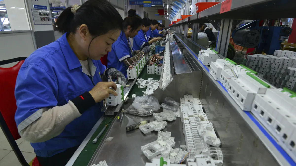 2025年4月15日。工人在中國中部安徽省阜陽市的一家電子裝置工廠組裝斷路器。(AP)