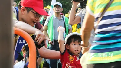 勞團立法院外抗議砍7天假,勞工爸爸教小孩丟雞蛋。(陳明仁攝)