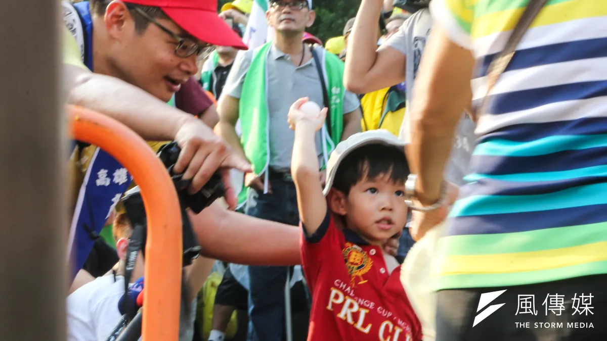勞團立法院外抗議砍7天假,勞工爸爸教小孩丟雞蛋。(陳明仁攝)