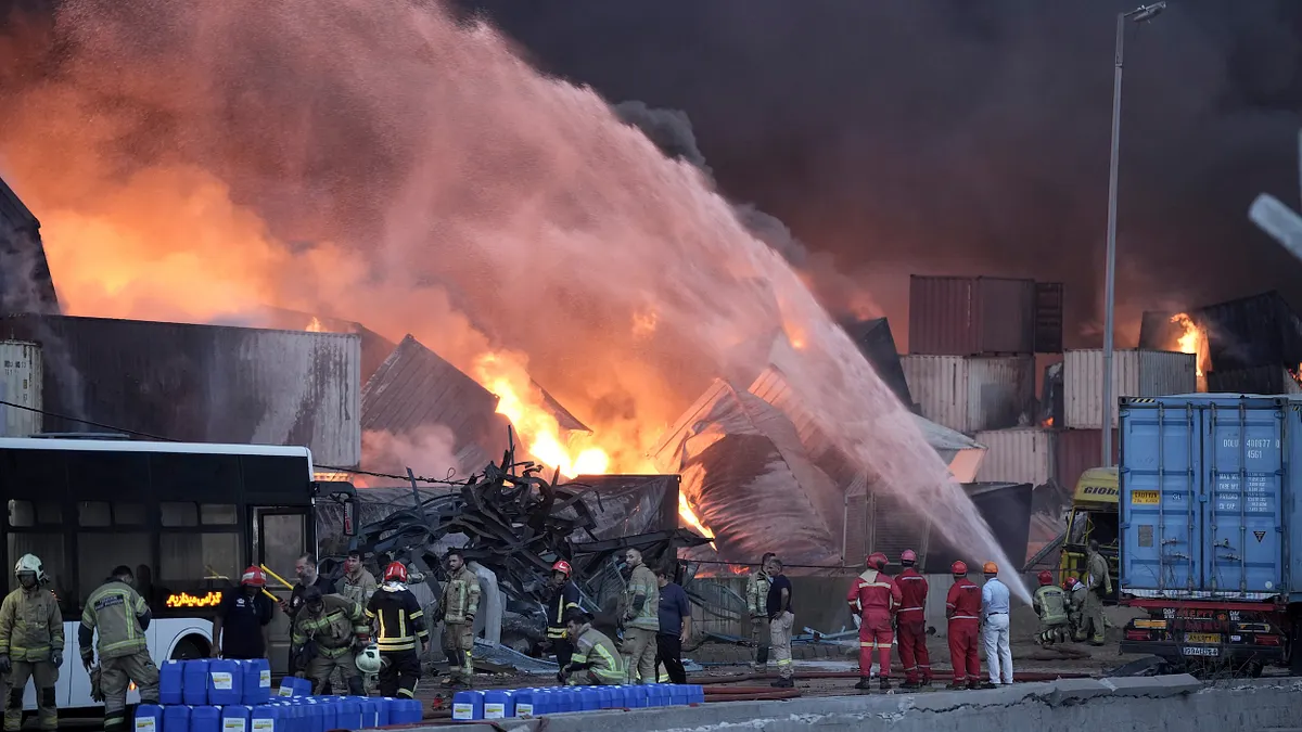 2025年4月27日、イラン南部シャヒドラジャイー港での爆発がまだ続いており、消防士たちが火災の鎮火に全力を尽くしている。(AP通信)