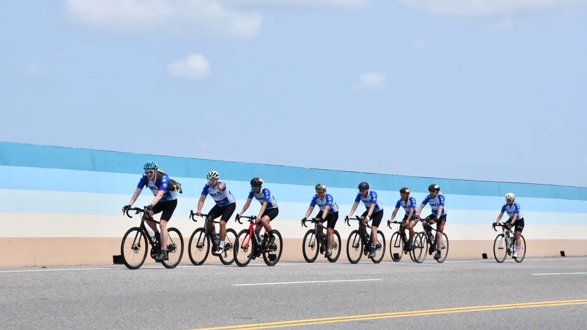 ANZCham riders in matching blue-and-white jerseys cycle along a coastal road in Penghu during the final leg of the five-day, 517-kilometre charity ride. (Photo: ANZCham Taiwan)