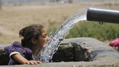 印度北部賈姆穆(Jammu)某個夏天的炎熱下午,一名女孩直接喝灌溉渠的水(美聯社)