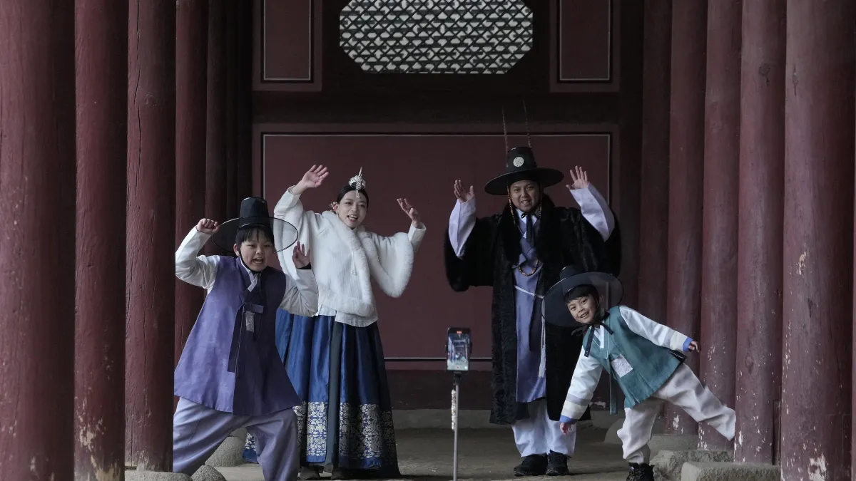 2025年1月,韓國首爾的遊客在景福宮穿著韓服自拍。(美聯社)