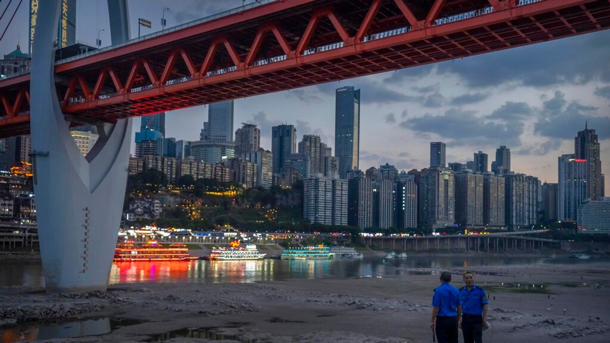 2022年8月20日,乾涸的嘉陵江河床與遠眺市景的兩名保安。(美聯社) 2022年8月20日,乾涸的嘉陵江河床與遠眺市景的兩名保安。(美聯社)