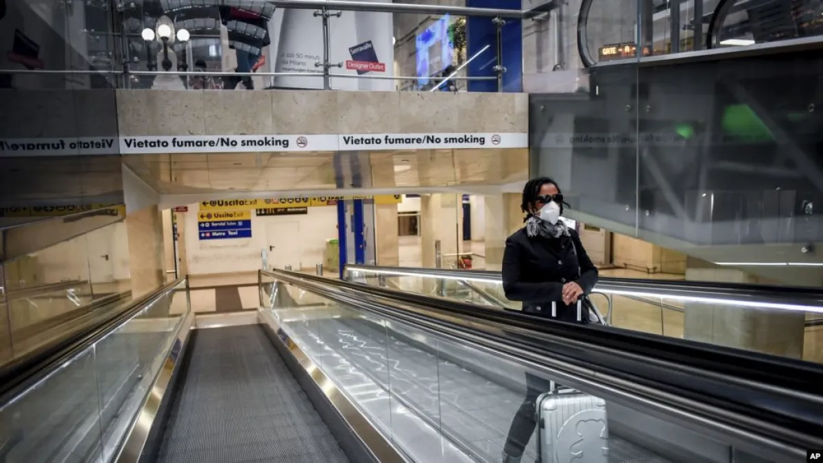 2020年3月8日,一名戴口罩的婦女在米蘭中央火車站的電梯上。(美國之音/AP)