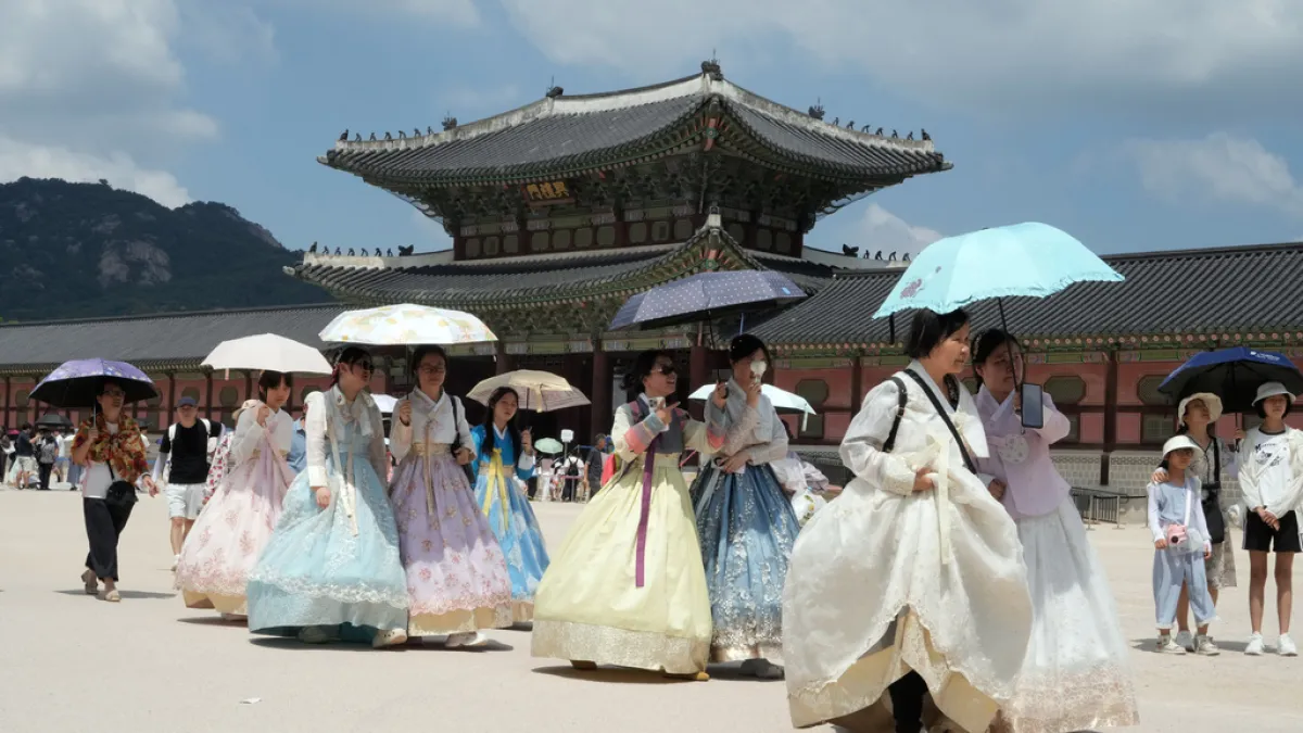 Foreign tourists in traditional hanbok explore Seoul's streets. Seasonal fruit stalls are emerging as a hidden gem for Taiwan travelers in South Korea, with grapes selling for less than NT$50 (USD$1.56) a bunch. (AP)