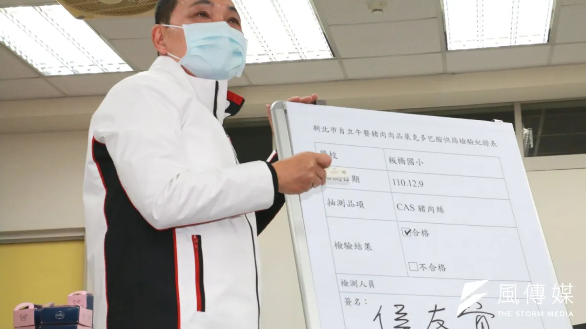 市長侯友宜示範用滴管將解凍過的生血水滴入快篩片之樣品收集區,靜置約5~10分鐘待試劑呈色後,隨即出現2條線結果,表示肉品不含萊克多巴胺。(圖/李梅瑛攝)