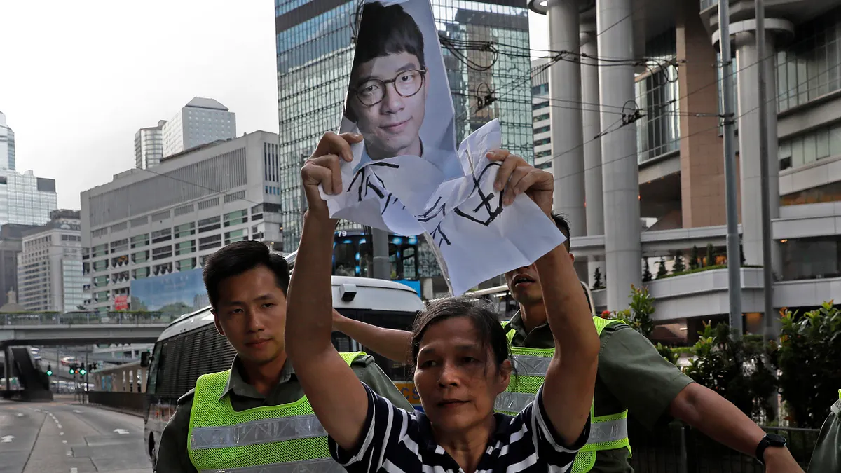 香港青年世代政治領袖黃之鋒、羅冠聰、周永康遭判刑入獄,支持者激動抗議(AP)